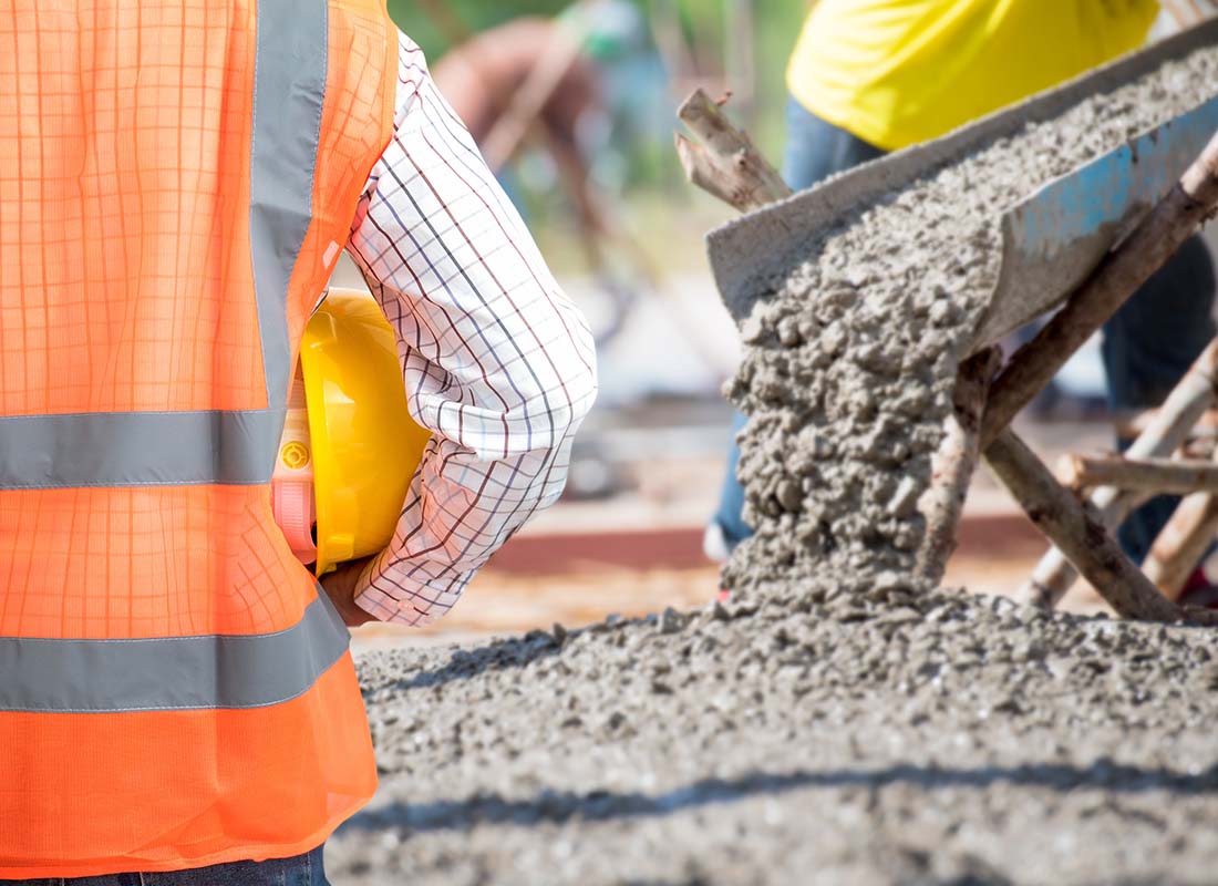 Concrete Contractor Insurance - Civil Engineer Checking the Concrete Pouring during a Commercial Concreting for the Floors of a New Building