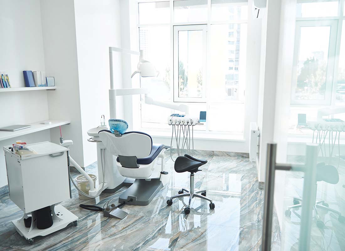 Dental Office Insurance - Empty Bright and Light Stomatological Room and Dentist Chair in a Modern Office Awaiting the Next Patient