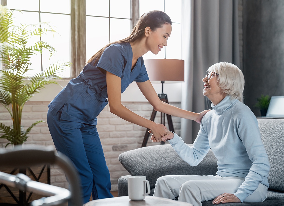 Medicare - Happy Female Professional Caregiver Taking Care of Elderly Woman at Home